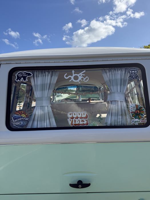 Close-up of Darla's rear window with curtains and colorful stickers