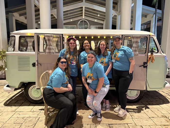 Group of volunteers posing together in front of Darla the VW bus
