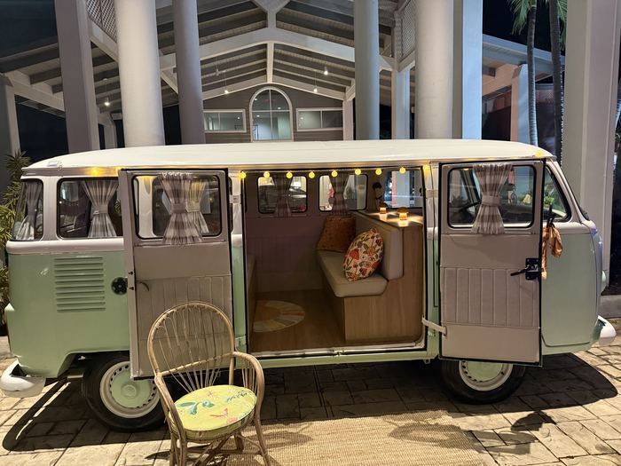 Couple dressed up posing with Darla the VW bus