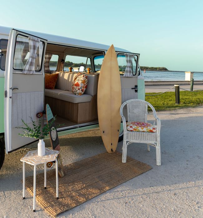 Close-up of surfboard and beach decor by Darla's open door