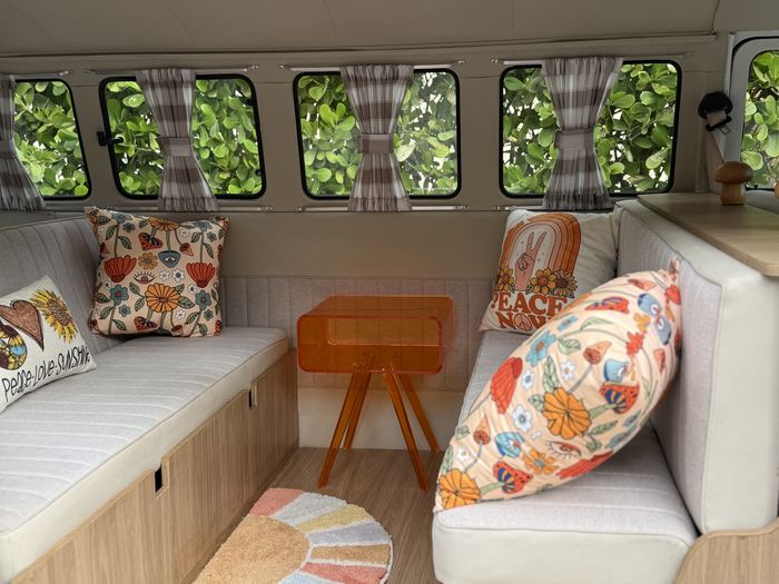 Interior bench seating with colorful pillows and greenery