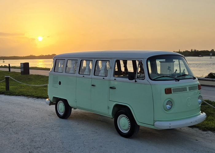 Darla the VW bus glowing at sunset by the water
