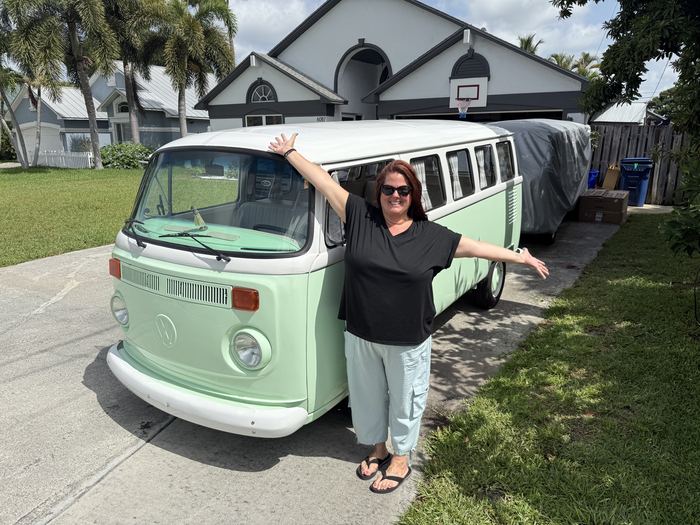 Owner celebrating with Darla the VW bus in the driveway